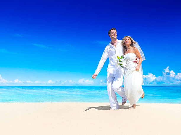 istock Bride and groom dressed in white on a sandy beachfront 171255531