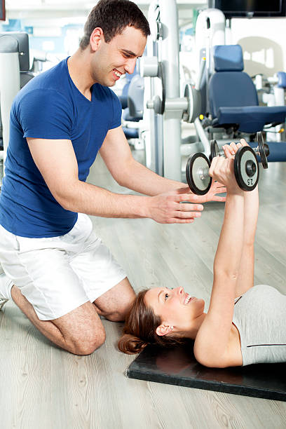 istock Woman in a gym with personal trainer 171255703