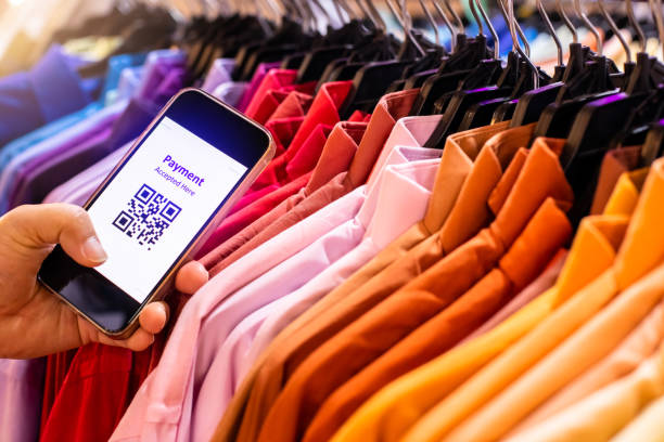 istock Selective focus to simulate payment QR code tag on smartphone with blurry many clothes in the store to accepted generate digital pay without money. 1712559000