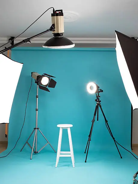 Photo-studio with lighting equipments and blue background paper
