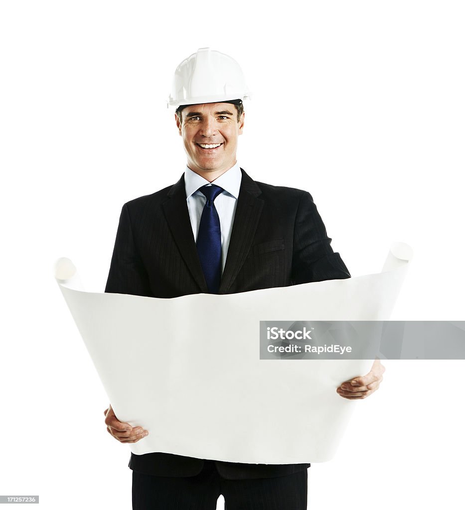 Uomo sorridente in abito e cappello duro tiene vuoto cianografie - Foto stock royalty-free di Elmetto da cantiere