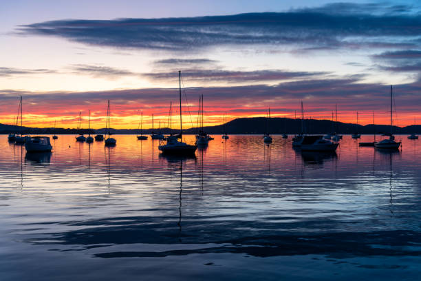 istock Sunrise over the water with boats, reflections and high cloud 1712573094