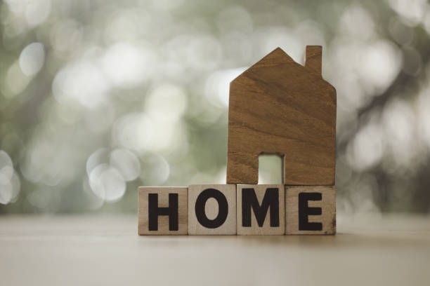 istock Small wooden house with text HOME with copy space. 1712581268