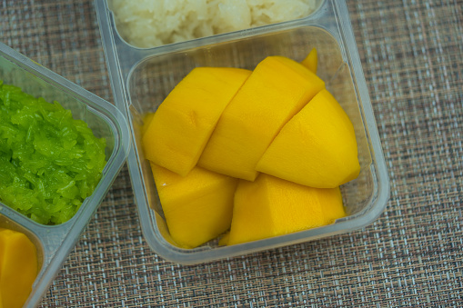 Thai famous delicious dessert. Sweet fresh ripe mango with sticky rice, green from pandan