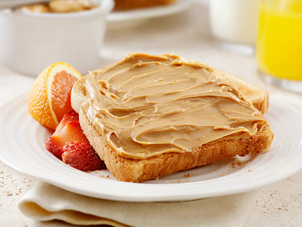 Peanut Butter on Toast Peanut Butter on Whole Wheat Toast with Orange Juice and Milk- Photographed on Hasselblad H3D2-39mb Camera Peanut Butter Toast stock pictures, royalty-free photos & images