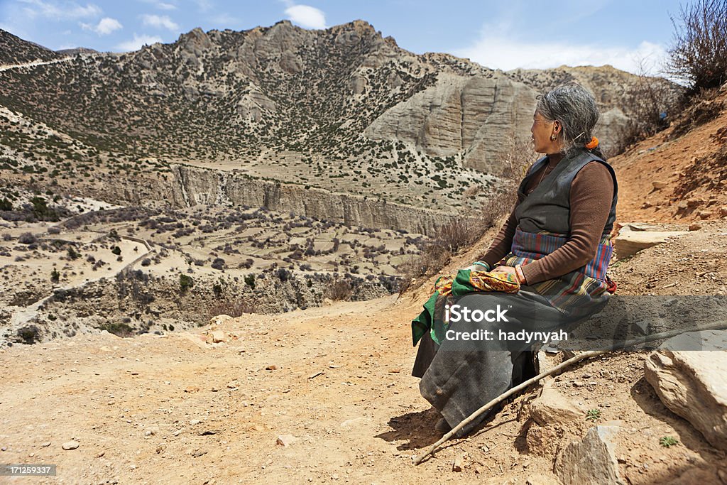 Tibetische Frau sitzt auf dem rock. Mustang, Nepal. - Lizenzfrei Eine Frau allein Stock-Foto