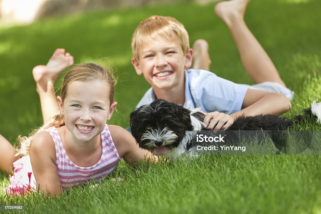 Niños felices jugando con perro mascota en el patio - Foto de stock de Perro libre de derechos