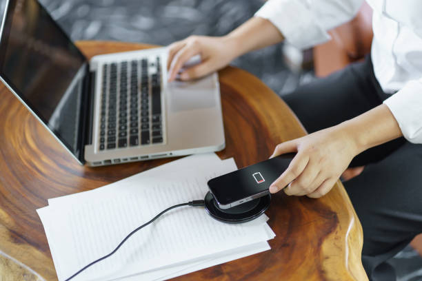 istock Charging mobile phone battery with wireless charging device in the table. Smartphone charging on a charging pad. Mobile phone near wireless charger Modern lifestyle technology concept 1712605782