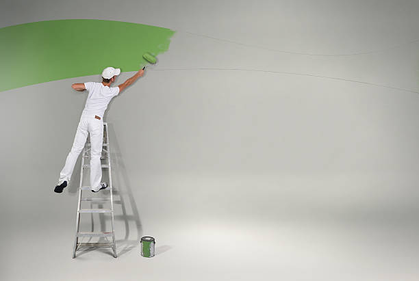 pittura della parete verde nuovo - uomo dipinge foto e immagini stock