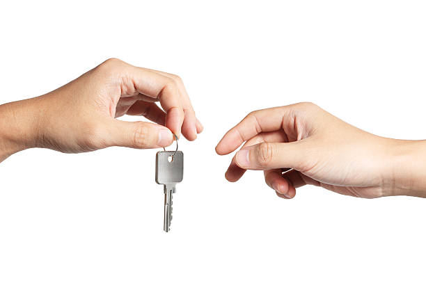 Key for You "Close-up on a hand giving a key to another, isolated on white background. Clipping path included." passing giving photos stock pictures, royalty-free photos & images