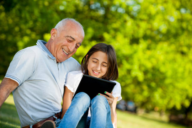 istock Grandfather and niece playing with digital tablet 171262011