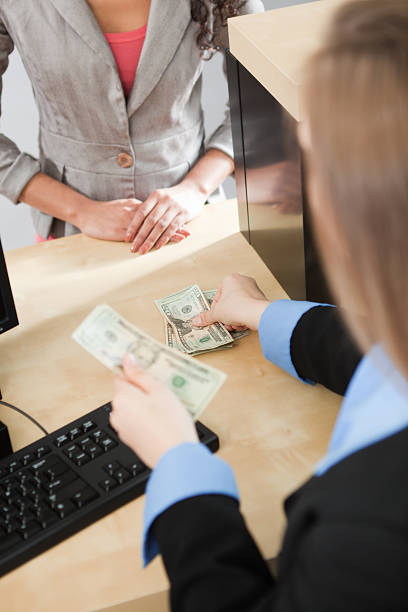 Subject: A bank customer making a transaction with a bank teller in a retail bank.