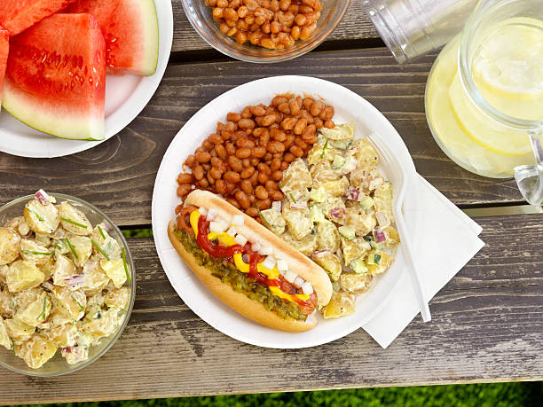 BBQ Hotdog with Lemonade "BBQ Hotdog with Mustard, Relish, Ketchup and Onions with Potato Salad and Baked Beans at a Picnic -Photographed on Hasselblad H3D2-39mb Camera" side dish stock pictures, royalty-free photos & images