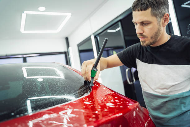 istock The process of installing protective film on the new red car. 1712628734