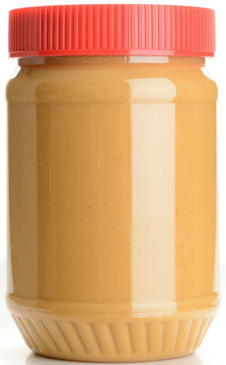 An unlabelled jar of peanut butter on a white background.