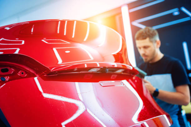 istock The process of installing protective film on the new red car. 1712630077