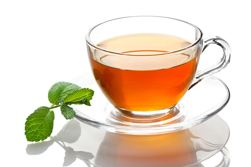 Cup of tea with mint leaves on a white background