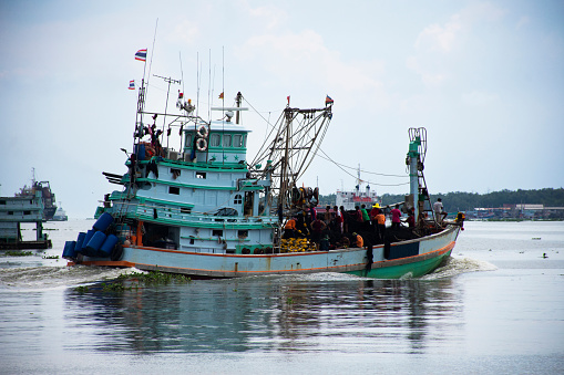 Thai fisher worker people sailing fishery fishing boat ship go to sea for catch fish and animal fish marine life in ocean waterfront Tha Chin river at Tha Chalom Mahachai city in Samut Sakhon Thailand