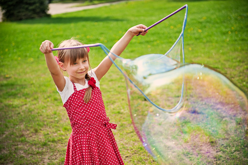 Little girl playing with bubbles.