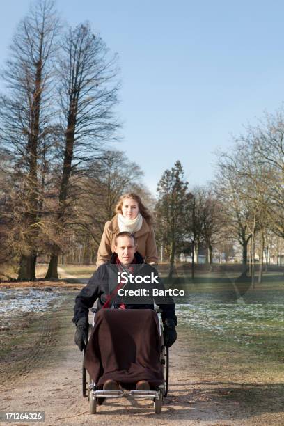 Photo libre de droit de Homme En Fauteuil Roulant Et Femme Dans Un Parc banque d'images et plus d'images libres de droit de Chaise roulante - Chaise roulante, Hiver, 25-29 ans