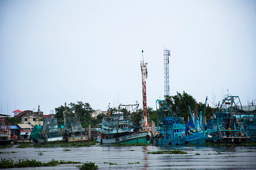 Fishery boat ship floating in water waiting catch fish marine life in ocean at fishing village of waterfront Tha Chin river at Tha Chalom Mahachai city on September 24, 2023 in Samut Sakhon, Thailand