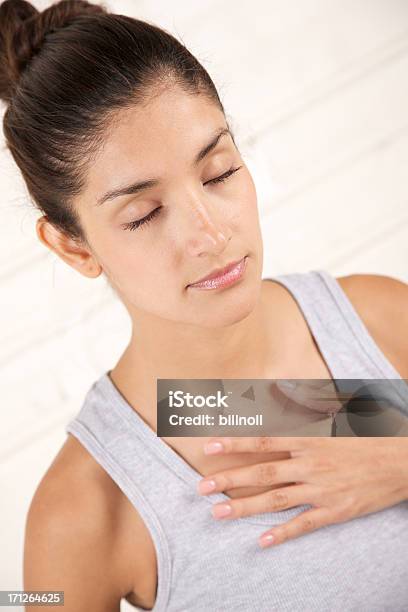 Attractive Female While Meditating And Breathing Stock Photo - Download Image Now - Hands On Chest, Breathing Exercise, Meditating