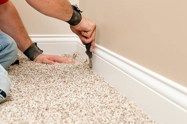 installer using carpet knife to tuck new floor - 地顫 個照片及圖片檔