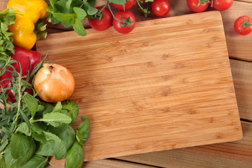 Herbs and vegetables with a blank chopping board.Alternative image in this collection: