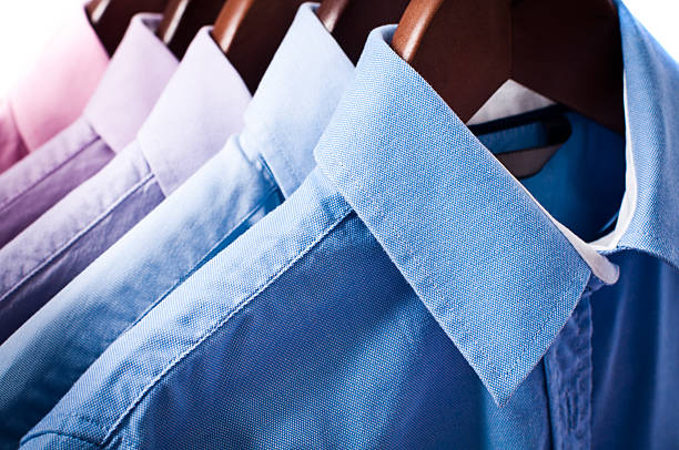 azul y rosa elegante botón de camisas en perchas de montaje - shirt hanger hanging blue fotografías e imágenes de stock