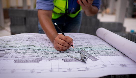 Architect engineer wearing safety uniform survey and working at structure building site blueprint check detail of work common work is engineer building architecture concept.