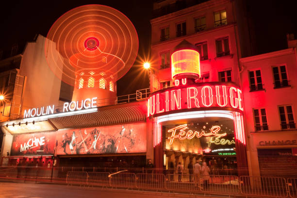 The Moulin Rouge Cabaret at Night, Paris, France "Paris, France - April 28, 2012: Le Moulin Rouge cabaret at saturday evening.  Le Moulin Rouge is one of the most famous places in Paris, built in 1889 and located close to Montmartre in the red-light district Pigalle in the 18th arrondissement of Paris." place pigalle stock pictures, royalty-free photos & images