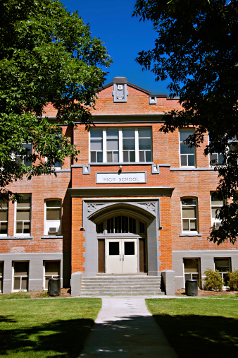 Exterior of large brick high school on a sunny day.