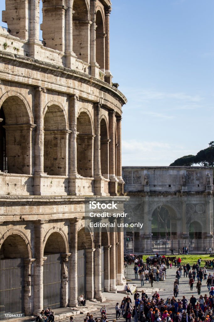 Tourists at the Colosseum "Rome, Italy - April 21, 2012: Tourists walking around the Colosseum and the Arch of Constantine on a sunny afternoon in Rome." Amphitheater Stock Photo