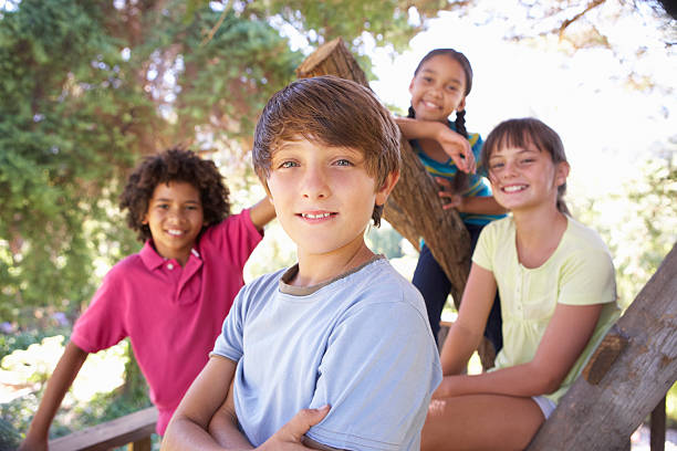 istock Group of elementary children hanging out in a treehouse 171266757