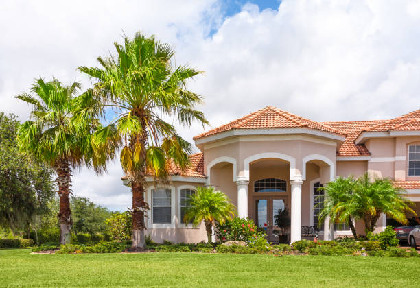 New Home with Palm Trees and Tropical Foliage New tile-roofed home with palm trees and lush tropical foliage. Florida. house residential structure roof rooftiles stock pictures, royalty-free photos & images