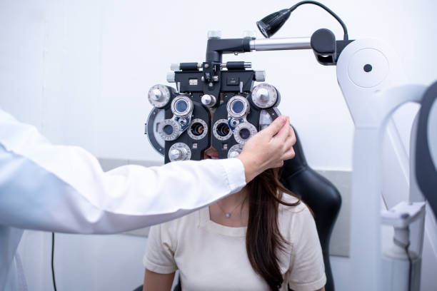 istock Woman optical shop customer doing eyesight measurement with optical phoropter check eye distance for eyeglasses is optical eye shop service. 1712670011