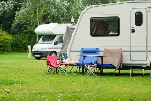 Caraavn site with sun loungers set up out side caravan in lovely countryside setting.