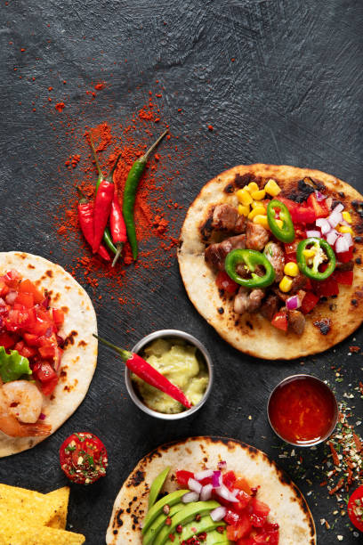 istock Tacos with salsa, vegetables and avocado on black background 1712672323