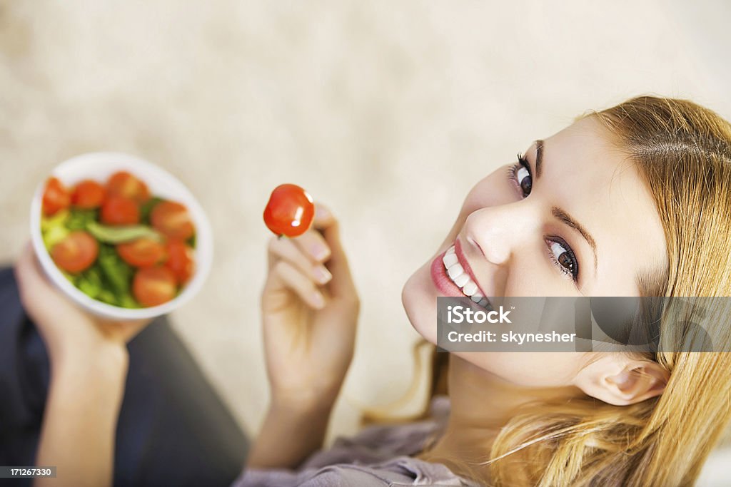 Primo piano di una donna di mangiare cibo sano. - Foto stock royalty-free di Pomodoro