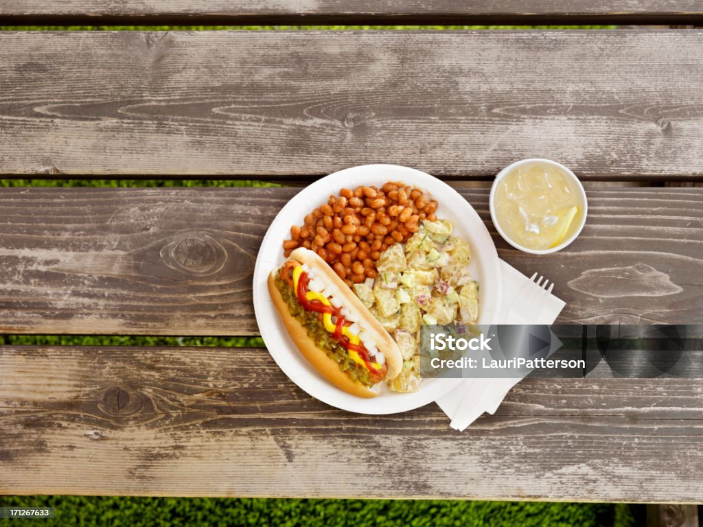 BBQ Hotdog with Lemonade "BBQ Hotdog with Mustard, Ketchup, Relish and Onions with Potato Salad and Baked Beans at a Picnic -Photographed on Hasselblad H3D2-39mb Camera" Picnic Table Stock Photo