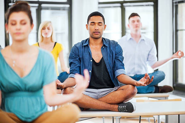 istock Large group of students meditating on the desks 171267756