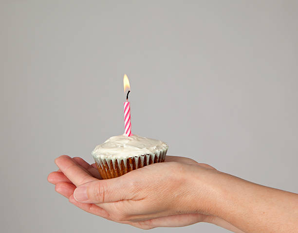istock Cupcake with One Pink Candle in Woman's Hands 171268681