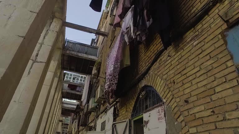 building in a dangerous ghetto with satellite dishes and laundry hanging from the balcony