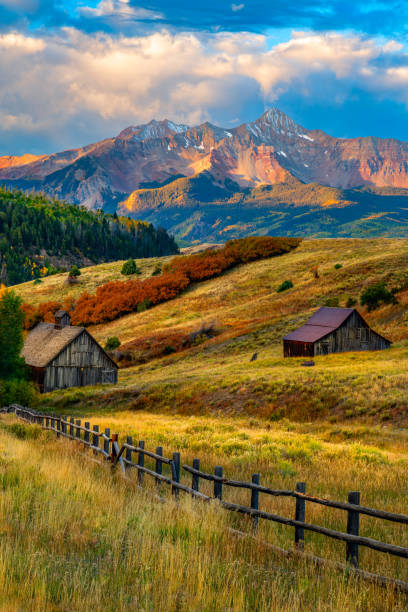Abandoned ranch building in the foothills of the Rocky Mountain landscape with blue sky and clouds in southwest Colorado during spring, USA.