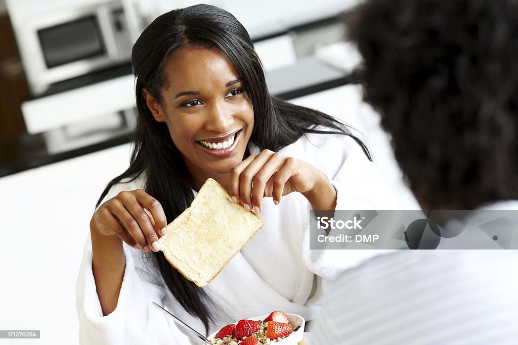 Pretty lady having breakfast with her husband Pretty young lady having breakfast with her husband at home Bread Stock Photo