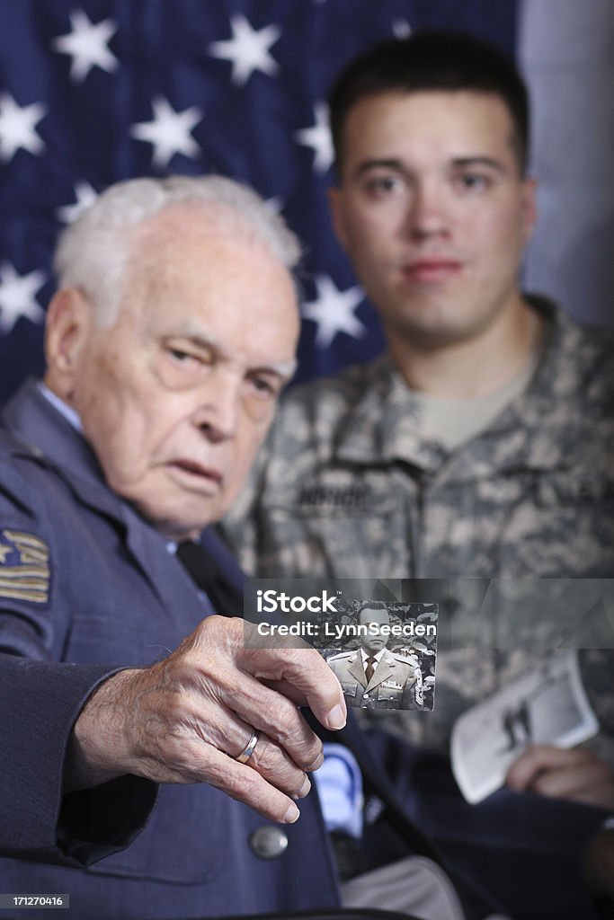 Grandfather and Grandson Veterans Grandfather sharing stories and old photos of himself with his grandson. Grandfather served in WWII and is now blind. Grandson served in Iraqi Freedom and is an active-duty soldier. USA Stock Photo