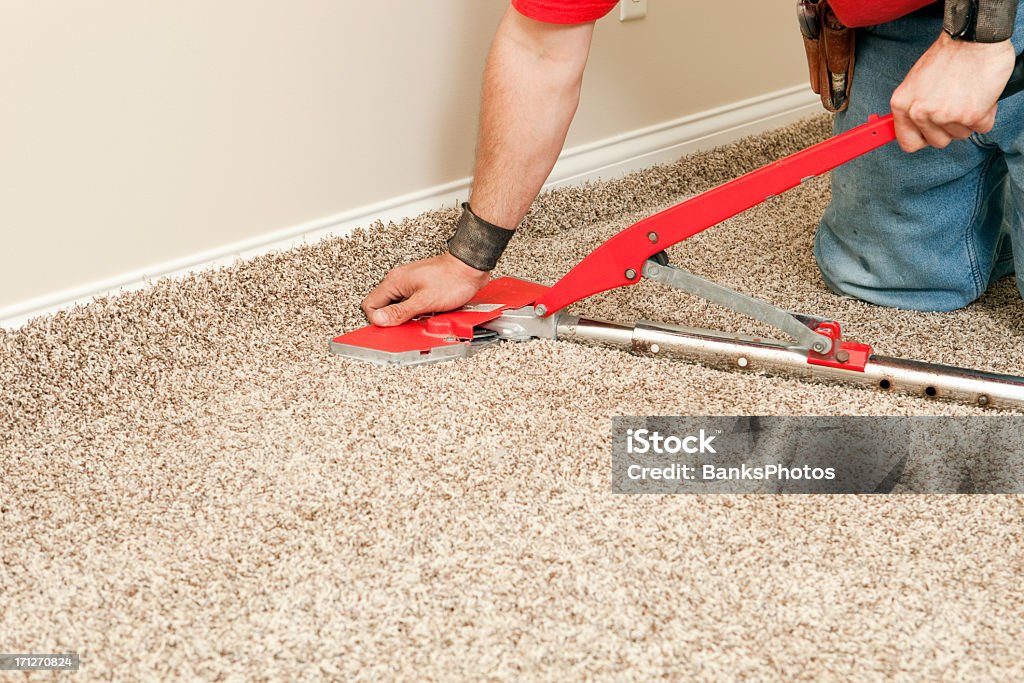 Instalador utilizando alfombra Extensor nueva dormitorio en el piso - Foto de stock de Moqueta libre de derechos