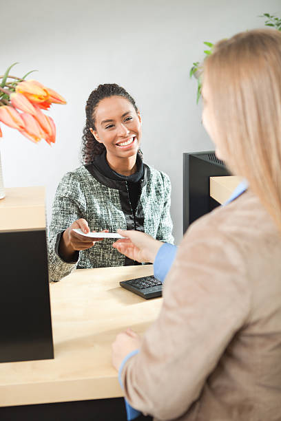 istock Friendly Teller Helping Customer in Retail Banking Window Counter Vt 171271120
