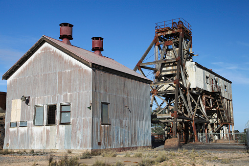 Head frame and buildings at old mining site in Broken Hill, NSW, Australia. This area of Broken Hill is where the mining company BHP was founded in 1885. They mined silver, lead and zinc.