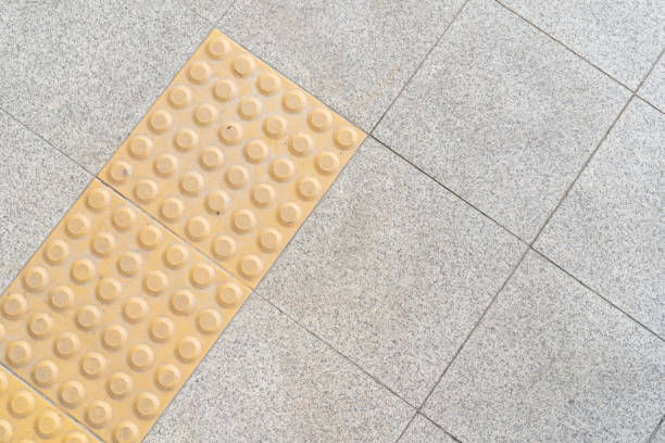 Close up yellow color blind floor tiles on public walkway. yellow blind floor track on the street